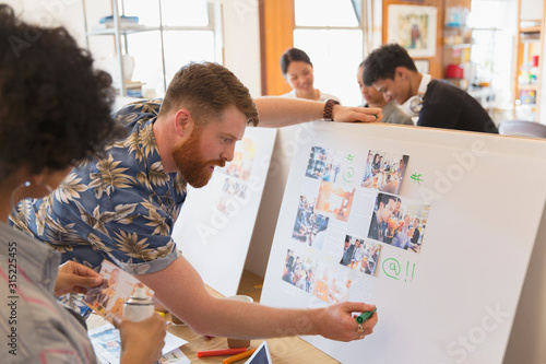 Creative designers reviewing story board proofs in office