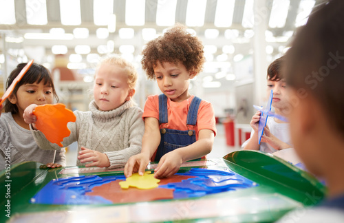 Kids playing at interactive exhibit in science center photo