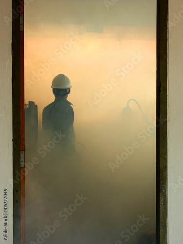 Wallpaper Mural Engineer fighting fire by fire extinguisher in control room with fire and smoke. Torontodigital.ca