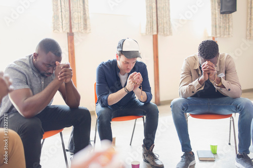 Men praying with rosaries in prayer group photo