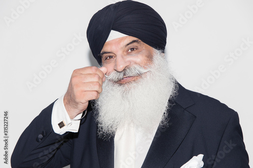 Portrait confident senior man with white beard wearing turban photo