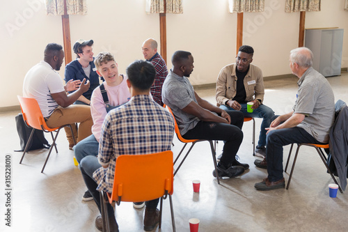 Men talking in group therapy in community center