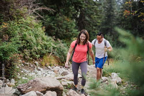 Couple hiking over rocks in woods photo