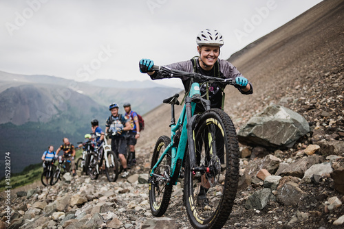Eager friends mountain biking on craggy trail photo