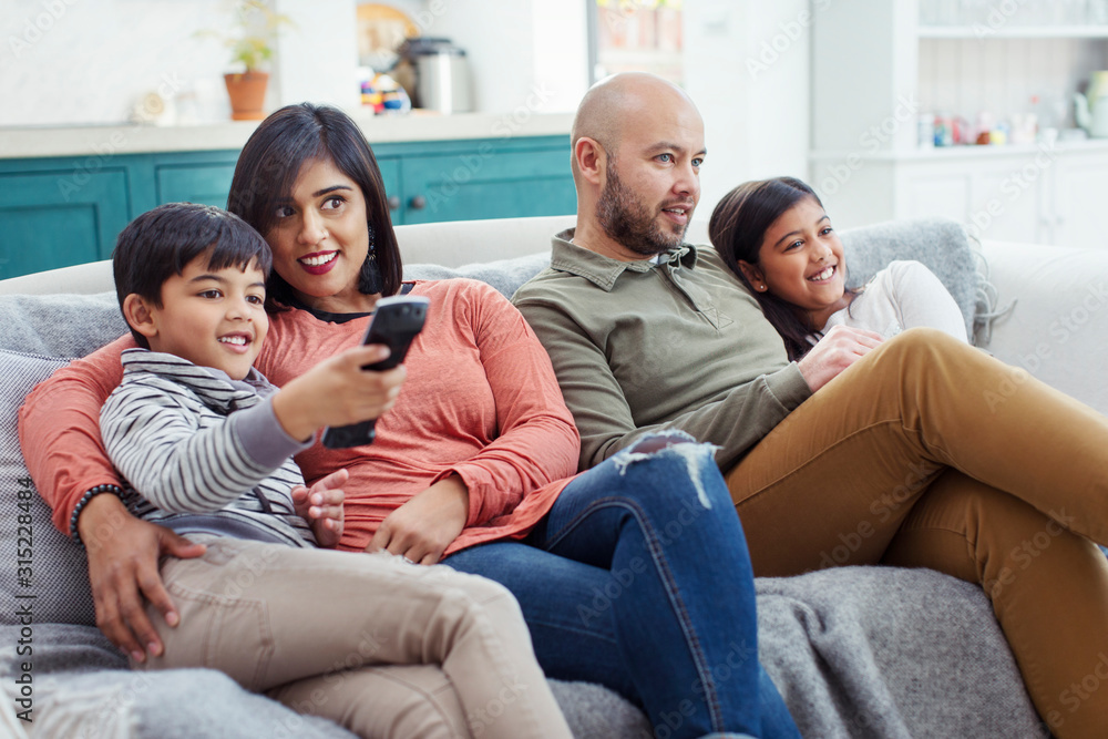 Family watching TV on living room sofa Family watching TV on living room sofa