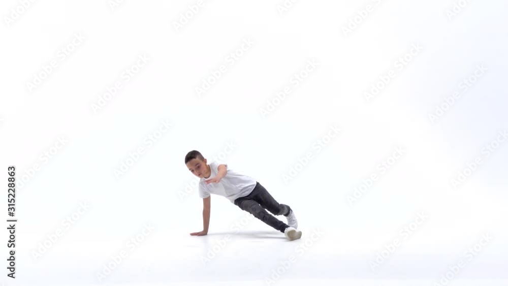 Little boy is dancing a modern dance on the white background in black leather jackets and jeans. Slow motion. Little boy is dancing a modern dance on the white background in black leather jackets and jeans. Slow motion.
