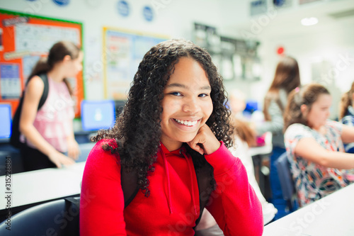 Portrait smiling, confident junior high school girl in classroom photo