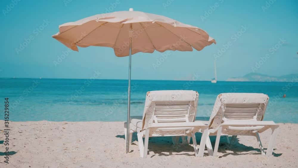 Sunbeds with umbrella on a paradise beach resort Sunbeds with umbrella on a paradise beach resort