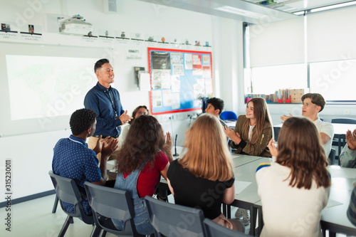 High school students clapping for teacher in debate class