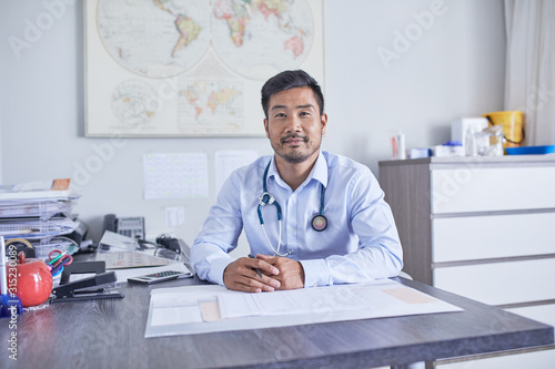 Portrait confident male doctor working in clinic doctors office photo