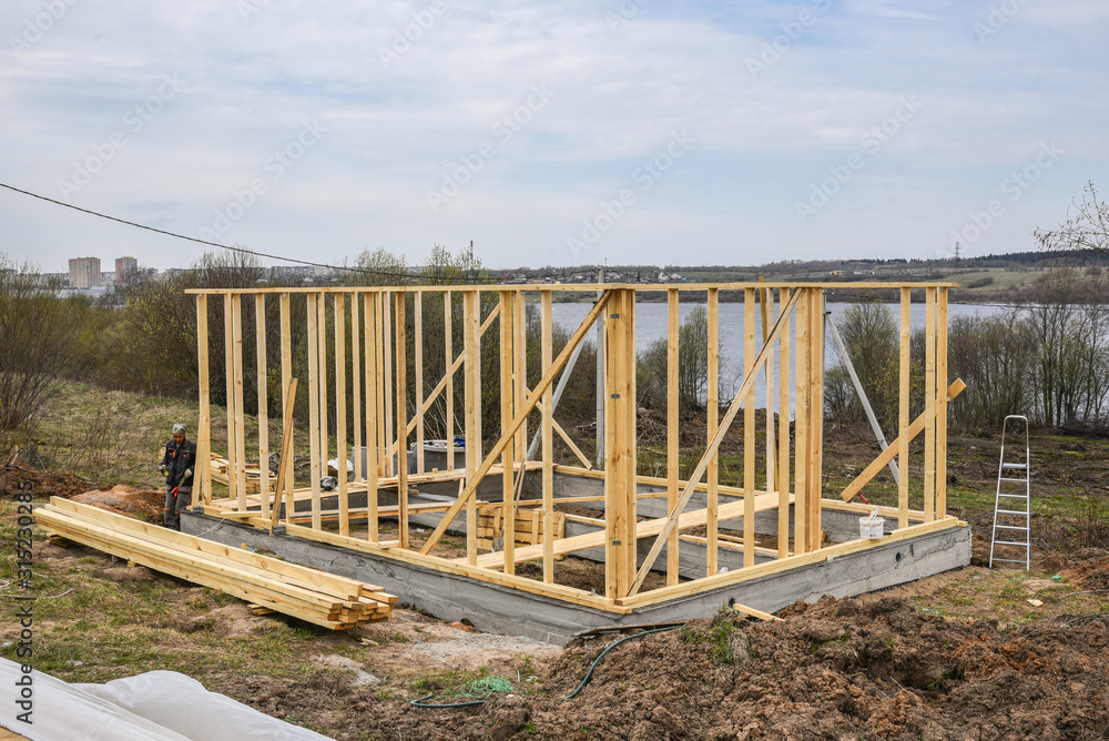 Construction home framing against blue sky.Wood frame residential building under construction.Building construction,wood framing structure at new property development site. mortgage, loan.