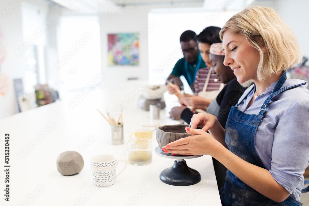 Woman making clay bowl in art class Woman making clay bowl in art class