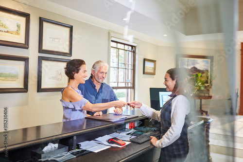 Mature couple checking in at hotel reception