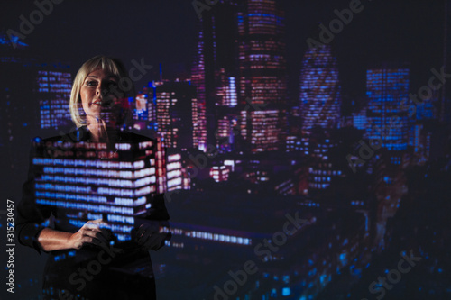 Double exposure businesswoman against highrise lights at night photo