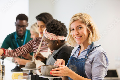 Portrait confident woman making clay bowl in art class photo