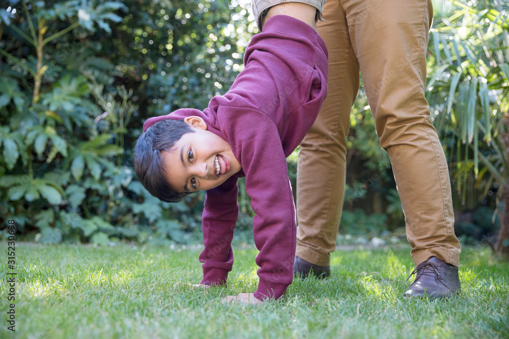Portrait playful boy hanging upside down in backyard Portrait playful boy hanging upside down in backyard