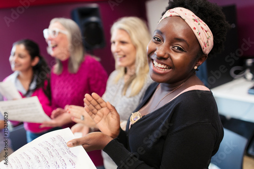 Happy woman singing in choir in music recording studio photo