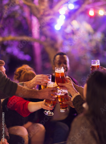 Friends toasting beer glasses at party photo