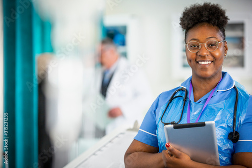 Portrait confident female nurse with digital tablet photo