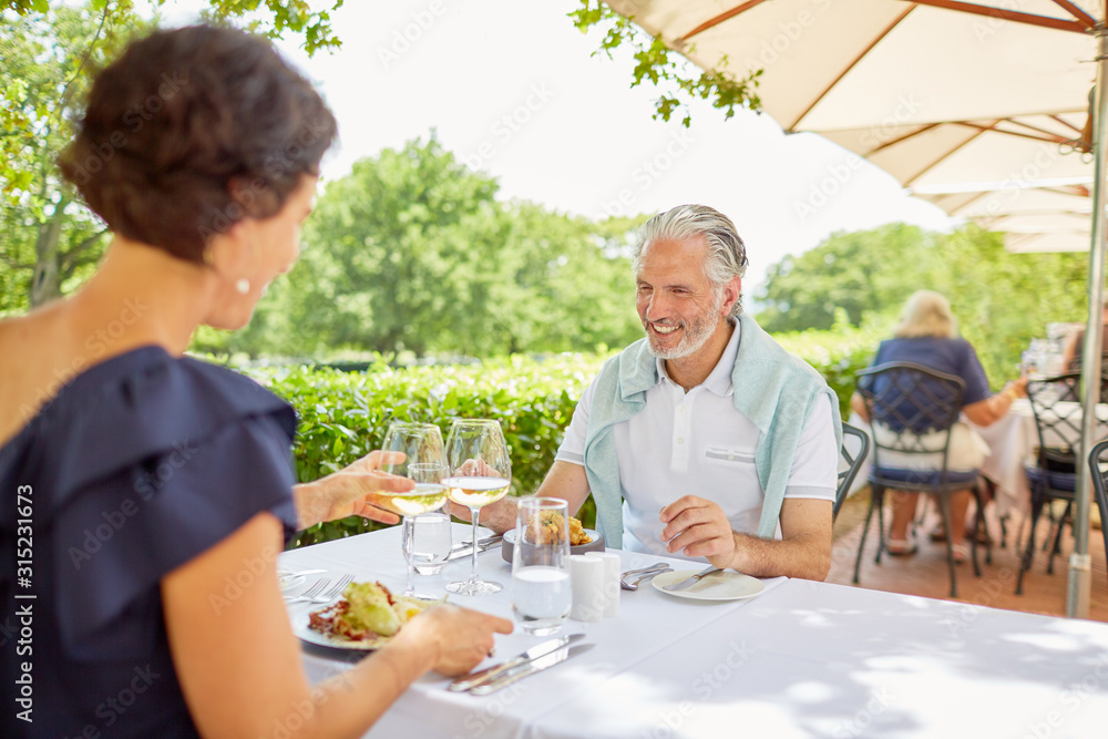 Mature couple dining at patio table Mature couple dining at patio table