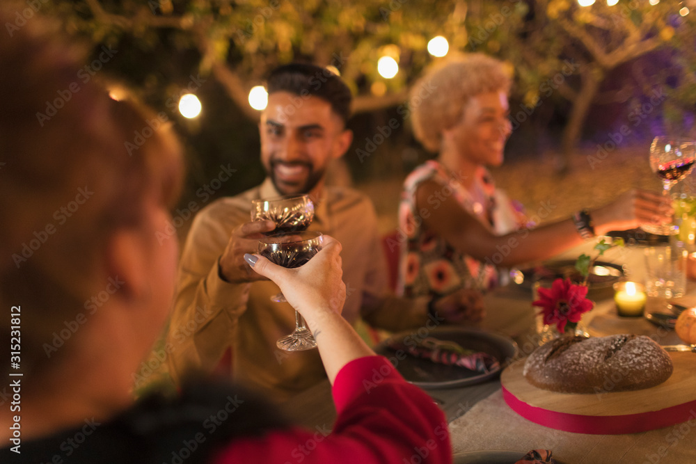 Friends toasting wine glasses at dinner garden party Friends toasting wine glasses at dinner garden party