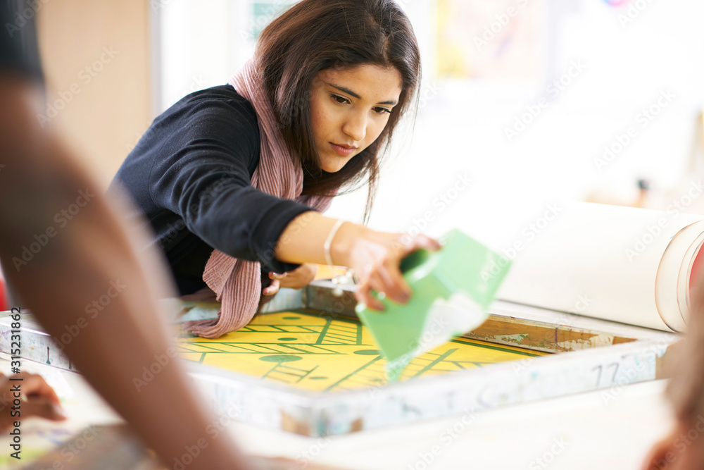 Female artist screen printing in art studio Female artist screen printing in art studio