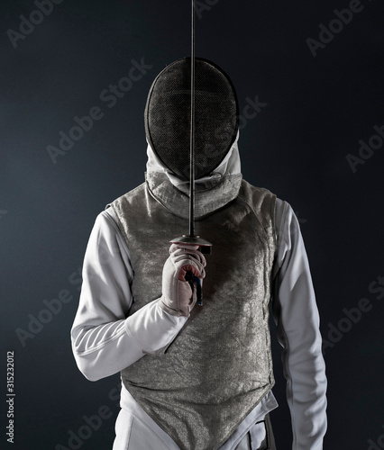 Portrait man in fencing uniform and mask photo