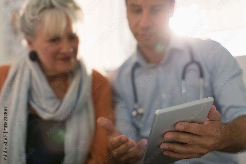 Male doctor showing digital tablet to patient Male doctor showing digital tablet to patient