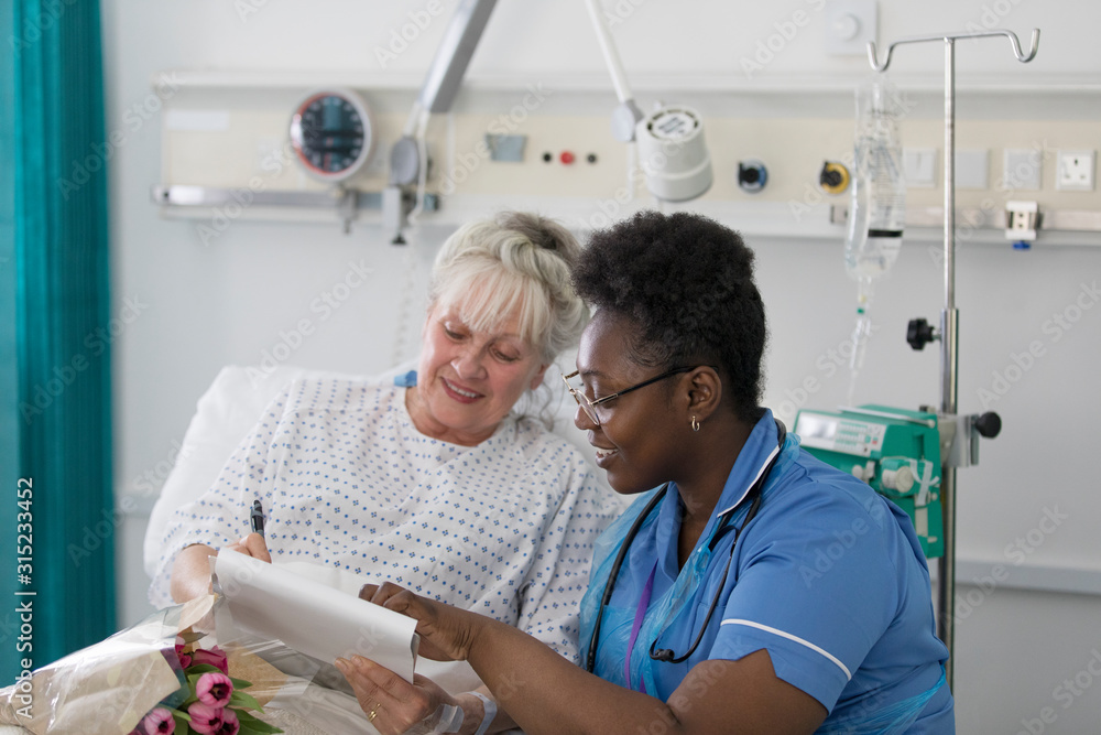 © Tom Merton/Caia Image - Female nurse discussing paperwork with senior patient in hospital room © Tom Merton/Caia Image - Female nurse discussing paperwork with senior patient in hospital room