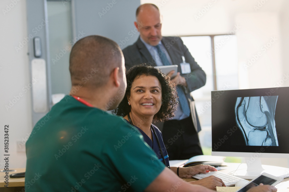 Nurses discussing digital x-ray at computer in doctors office Nurses discussing digital x-ray at computer in doctors office