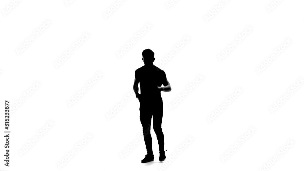 Silhouette of Man is dancing breakdance on the white background in simple grey t-shirt and grey jeans. Slow motion. Silhouette of Man is dancing breakdance on the white background in simple grey t-shirt and grey jeans. Slow motion.