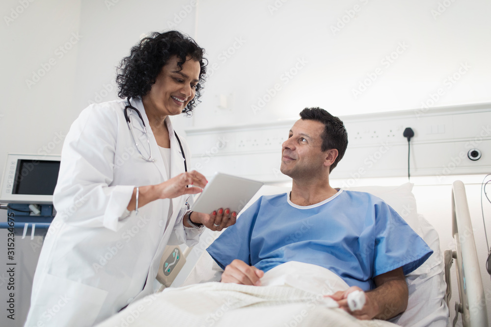 Doctor with digital tablet making rounds, talking with patient in hospital room Doctor with digital tablet making rounds, talking with patient in hospital room