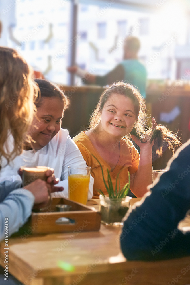 Young women with Down Syndrome talking in cafe Young women with Down Syndrome talking in cafe