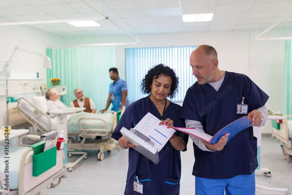 © Tom Merton/Caia Image - Doctors with medical charts making rounds, consulting in hospital ward © Tom Merton/Caia Image - Doctors with medical charts making rounds, consulting in hospital ward