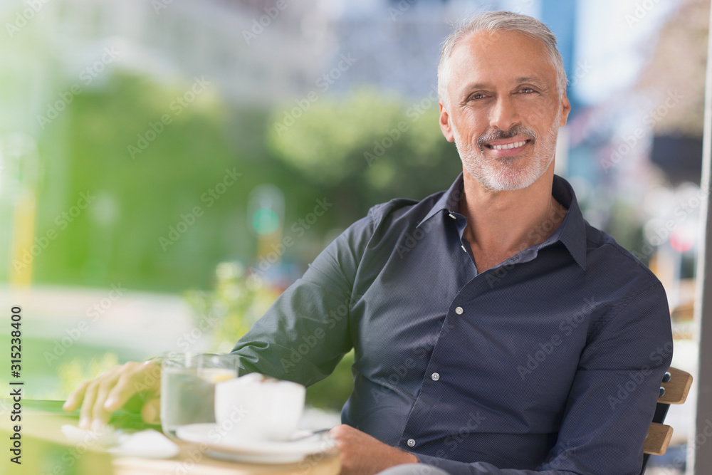Portrait smiling man drinking coffee at urban sidewalk cafe Portrait smiling man drinking coffee at urban sidewalk cafe