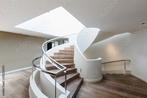 Wood spiral staircase in modern luxury home showcase interior photo