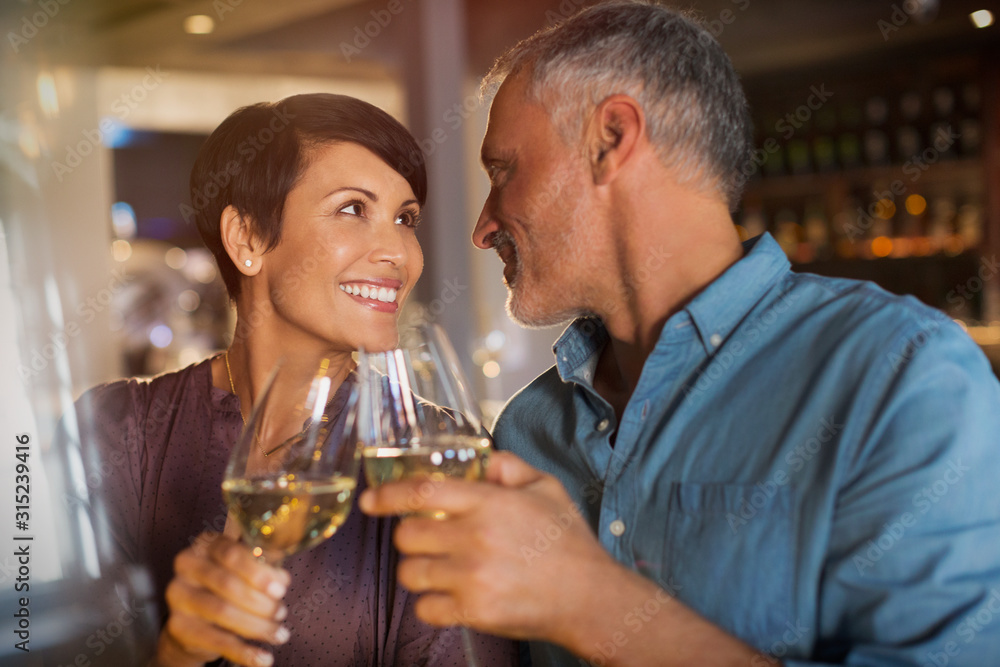 Couple toasting white wine glasses in restaurant Couple toasting white wine glasses in restaurant