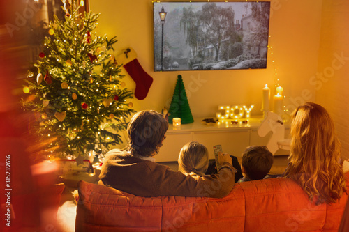 Family watching TV in Christmas living room photo