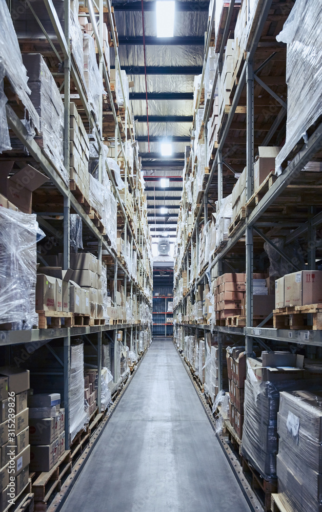 Merchandise cardboard boxes stacked on shelves in distribution warehouse Merchandise cardboard boxes stacked on shelves in distribution warehouse