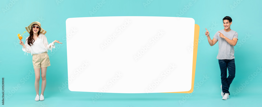 Smiling happy casual Asian couple with empty white billboard Smiling happy casual Asian couple with empty white billboard