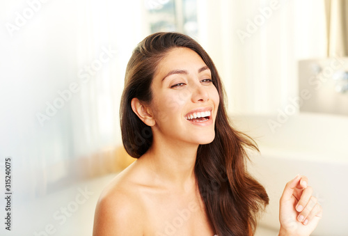 Laughing brunette woman with bare shoulders