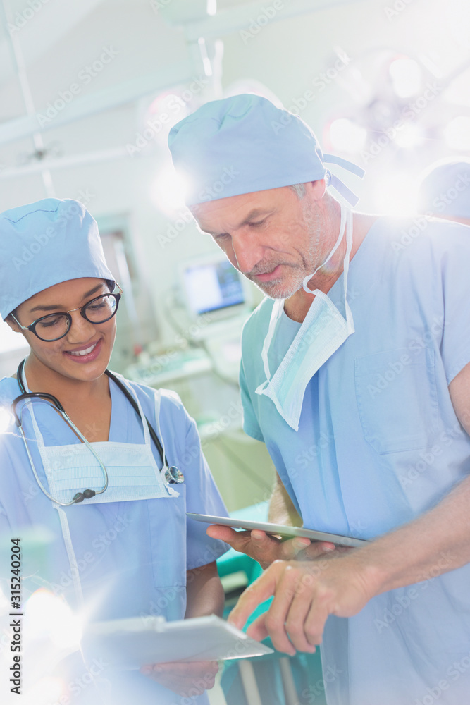 Surgeons with digital tablet and clipboard talking in operating room Surgeons with digital tablet and clipboard talking in operating room