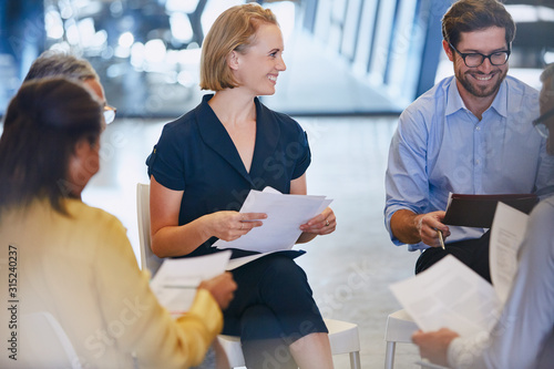 Smiling business people discussing paperwork in meeting