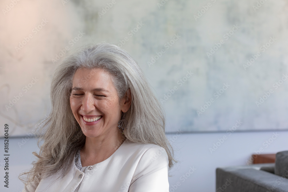 Mature woman laughing with eyes closed Mature woman laughing with eyes closed