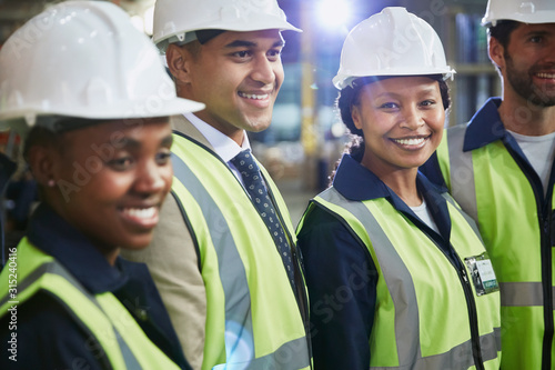 Portrait confident female worker with coworkers in distribution warehouse photo