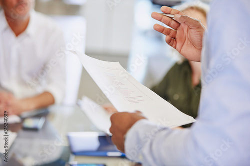 Businessman with paperwork gesturing in meeting