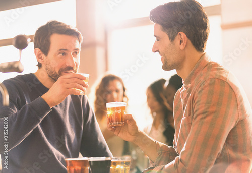 Men friends sampling beer at microbrewery bar photo