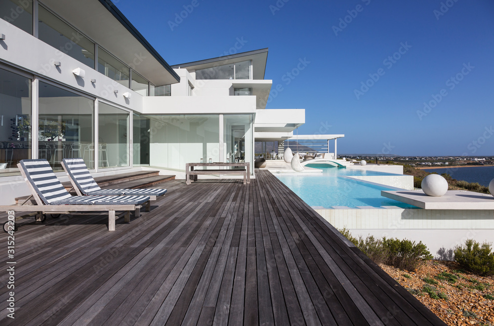 Sunny modern luxury home showcase exterior patio with infinity pool Sunny modern luxury home showcase exterior patio with infinity pool