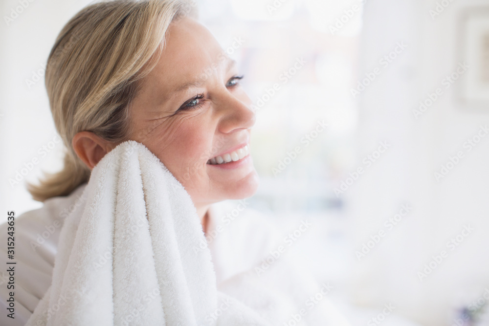 Smiling mature woman drying face with towel Smiling mature woman drying face with towel