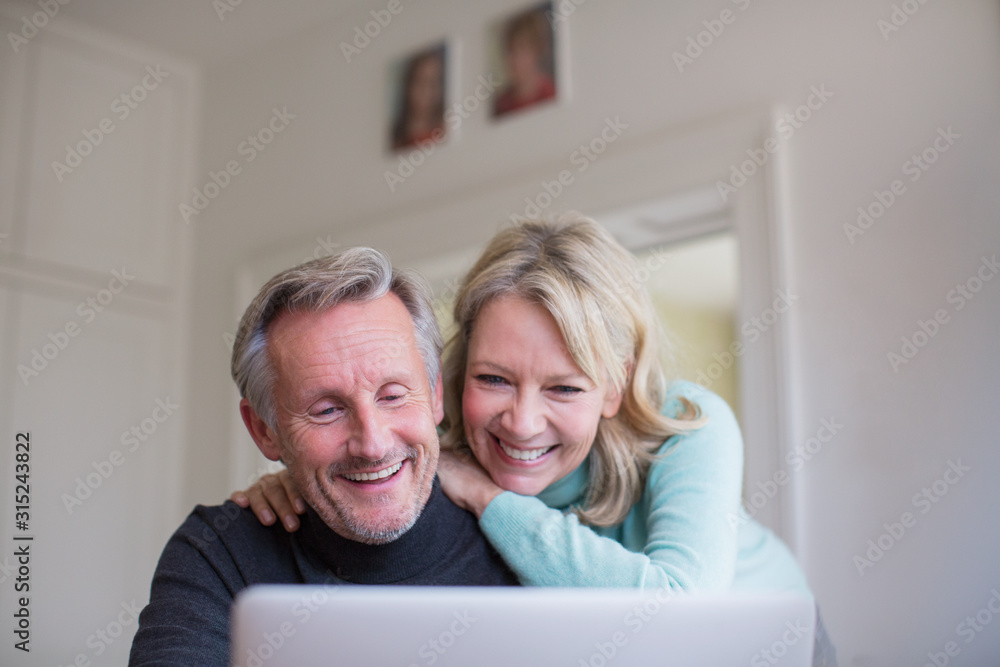 Smiling, happy mature couple using laptop Smiling, happy mature couple using laptop